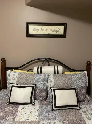 a bed with pillows and a sign on the wall at Cozy Lodge Suite in Sylvan Lake