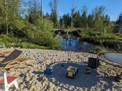 a sandy beach with toys in the sand next to a river at Farmhouse cabin on 33 acre farm in Powell River