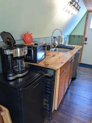 a kitchen with a black refrigerator and a counter top at Farmhouse cabin on 33 acre farm in Powell River