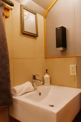 a bathroom sink with a mirror and a tv on the wall at Rustic Beaverfoot Lodge Room N8 in Parson