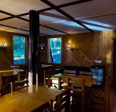 a dining room with a table and chairs and windows at Rustic Beaverfoot Lodge Room N10 in Parson