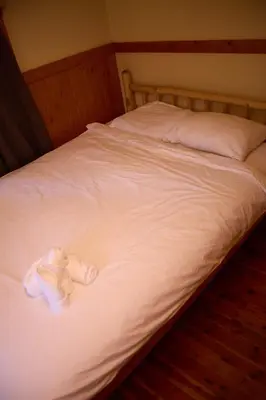 a bed with white towels and a stuffed animal on it at Rustic Beaverfoot Lodge Room N10 in Parson