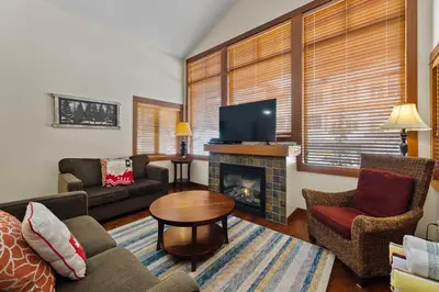 a living room with a couch and a fireplace at Settler's Crossing #56 ski-in ski-out condo with private hot tub in Sun Peaks