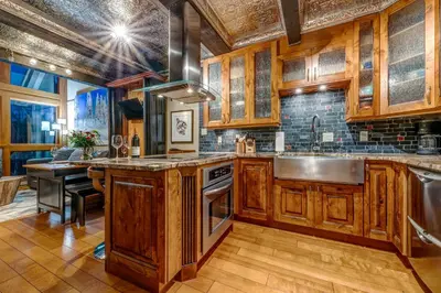 a kitchen with wooden cabinets and a sink at Greystone Lodge 320 Ski-in Out in Whistler