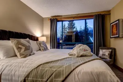 a bedroom with a bed and a window at Greystone Lodge 320 Ski-in Out in Whistler
