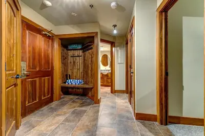a hallway with wooden doors and tile flooring at Greystone Lodge 320 Ski-in Out in Whistler