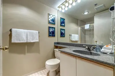 a bathroom with a sink and a toilet and a mirror at Greystone Lodge 318 Ski-in Out in Whistler