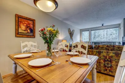 a dining room with a wooden table with chairs at Greystone Lodge 332 Ski-in Out in Whistler