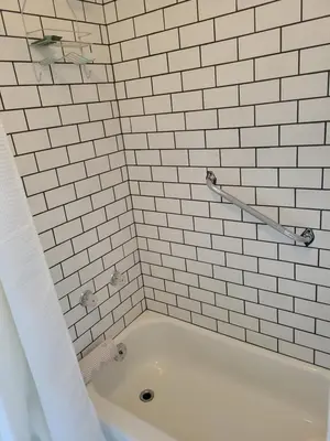 a white tiled bathroom with a bath tub at Cross Suite - MistyRiver Lodge in Radium Hot Springs