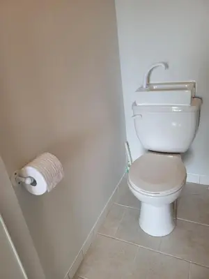 a bathroom with a toilet and a roll of toilet paper at Cross Suite - MistyRiver Lodge in Radium Hot Springs