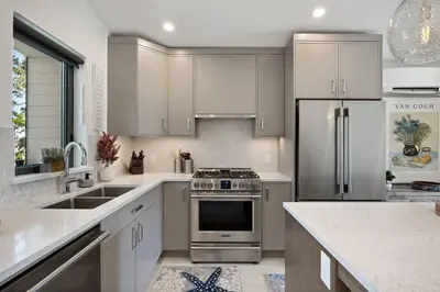 a kitchen with stainless steel appliances and white cabinets at The Beach House at Saratoga #2 in Oyster Bay