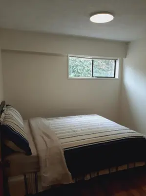 a bed in a room with a window at Farmestate in Vancouver