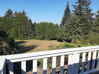 a white fence with trees in the background at Farmestate in Vancouver