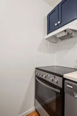 a kitchen with a black stove and blue cabinets at Reach Your Peak, Ski In, Ski Out, Pool, Hot Tub in Panorama