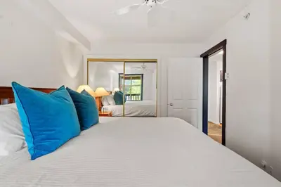 a bedroom with a large white bed with blue pillows at Reach Your Peak, Ski In, Ski Out, Pool, Hot Tub in Panorama