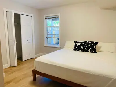 a bedroom with a bed with a black and white pillow at 2 Beds Guest Suite to Yourself at Coquitlam Centre Mall in Port Coquitlam