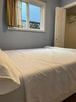 a white bed in a bedroom with a window at 2 Beds Guest Suite to Yourself at Coquitlam Centre Mall in Port Coquitlam
