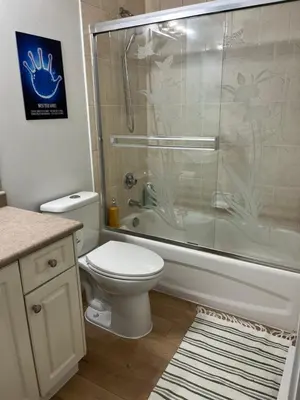 a bathroom with a toilet and a glass shower at 2 Beds Guest Suite to Yourself at Coquitlam Centre Mall in Port Coquitlam