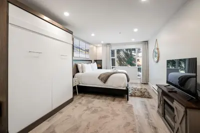 a bedroom with a bed and a flat screen tv at Ski In & Out, Heart of Upper Village in Whistler