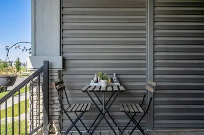 a small table on a porch with two chairs at Large House Near Calgary Airport with Central AC, Double Car Garage Parking, Upgrade Stay, Netflix, Sleeps 8 in Calgary