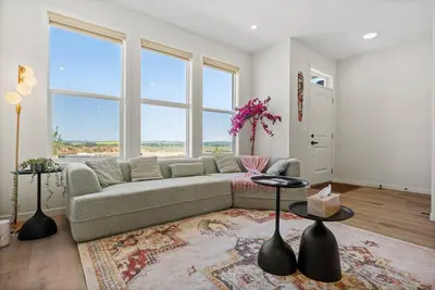 a living room with a couch and a large window at Entire 4 Bedroom House Including Basement with King Size Bed, Upgrade Your Stay, Netflix, Sleeps 14 in Balzac