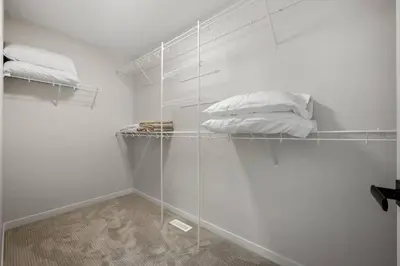 a room with white walls and shelves with pillows at Entire 4 Bedroom House Including Basement with King Size Bed, Upgrade Your Stay, Netflix, Sleeps 14 in Balzac
