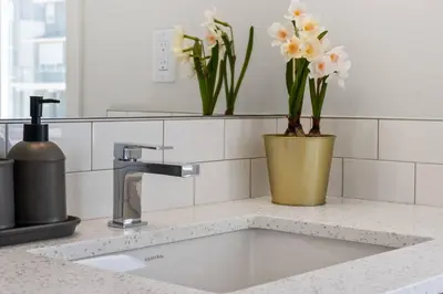 a kitchen counter with a sink with flowers in a vase at Entire 4 Bedroom House Including Basement with King Size Bed, Upgrade Your Stay, Netflix, Sleeps 14 in Balzac