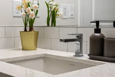 a kitchen counter with a sink with flowers on it at Entire 4 Bedroom House Including Basement with King Size Bed, Upgrade Your Stay, Netflix, Sleeps 14 in Balzac