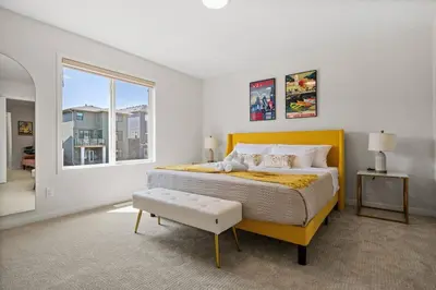 a bedroom with a yellow bed and a window at Entire 4 Bedroom House Including Basement with King Size Bed, Upgrade Your Stay, Netflix, Sleeps 14 in Balzac