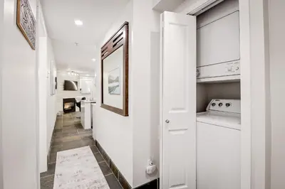 a hallway with white walls and a white kitchen at Whistler Village, Private Hot Tub, Free Parking in Whistler