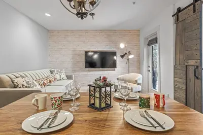 a living room with a table with wine glasses on it at L109 Canmore World Class Solara Resort - Hot tub, Pool, Gym, AirCon, Free Parking & Netflix in Canmore