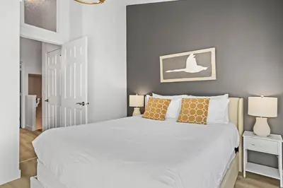 a bedroom with a large white bed with orange pillows at B233 Mountain View 2BD 2BT AC BonFire BBQ Townhome Close to Banff in Canmore