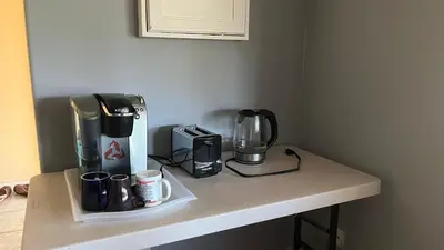 a counter with a coffee maker and coffee cups on it at Big band home in Burnaby