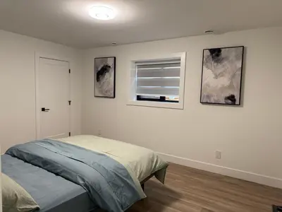 a white bedroom with a bed and a window at Calm & Cozy Private Suite in Surrey