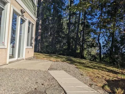 a door to a house with a lawn and trees at Charming 3 Bedroom Suite in Victoria