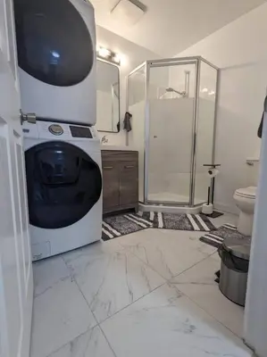 a bathroom with a shower and a large tv in it at Charming 3 Bedroom Suite in Victoria