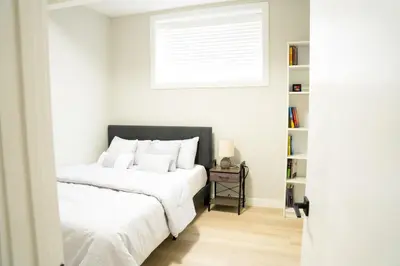 a bedroom with two beds and a window at The Old Trafford - Stylish 2 bed suite in Calgary