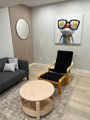 a living room with a couch and a table and a chair at The Old Trafford - Stylish 2 bed suite in Calgary