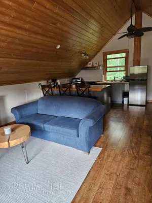 a living room with a blue couch and a table at Carriage House - 2 suites- HIKE & REST - EV plug in Golden