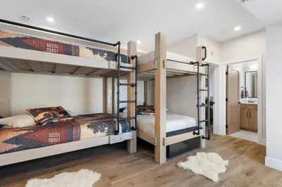 a bedroom with two bunk beds and a bathroom at Luxe Retreat by Canadian Rockies Vacation Rentals in Canmore