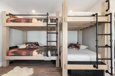 a room with three bunk beds and a bed at Luxe Retreat by Canadian Rockies Vacation Rentals in Canmore
