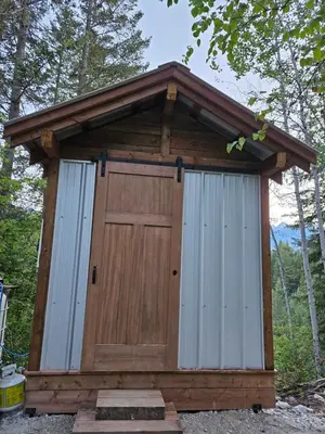 a wooden out house with a wooden door at Zest Campers Ltd in Golden