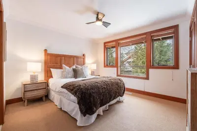 a bedroom with a bed and two windows at Montebello 4877 by Outpost Whistler in Whistler