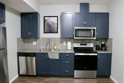 a kitchen with blue cabinets and a microwave at Parkside Luxury Stay with Xbox Entertainment in Calgary