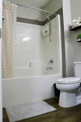 a white bathroom with a toilet and a shower at Parkside Luxury Stay with Xbox Entertainment in Calgary