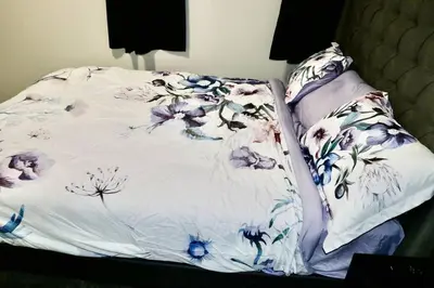 a bed with a blanket with flowers on it at Parkside Luxury Stay with Xbox Entertainment in Calgary
