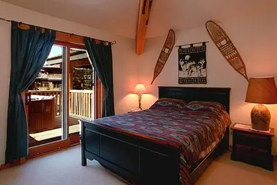 a bedroom with a large bed and a balcony at Whistler Highcamp in Whistler