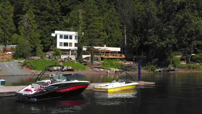 two boats are docked in a body of water at Ozarks Luxurious Lakeside Villa at Harrison Lake in Harrison Hot Springs