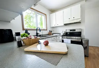 a kitchen with a cutting board and a bowl of apples at Cozy House in Haines Junction in Haines Junction