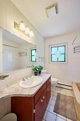 a white bathroom with a sink and a toilet at Chinook Executive Entire House in Calgary